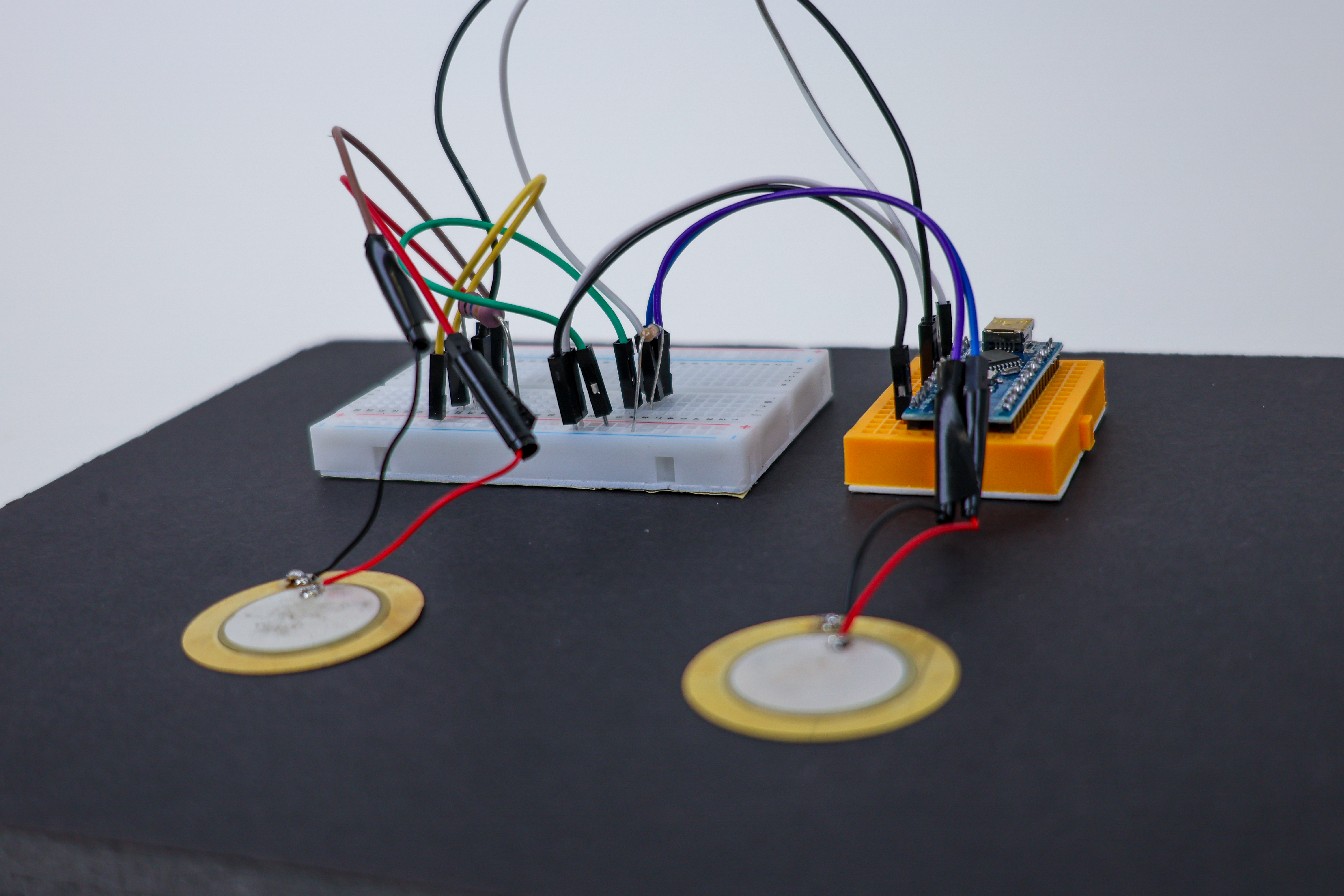 Breadboard circuit showing Piezo sensor and 10M Ohm resistor configuration