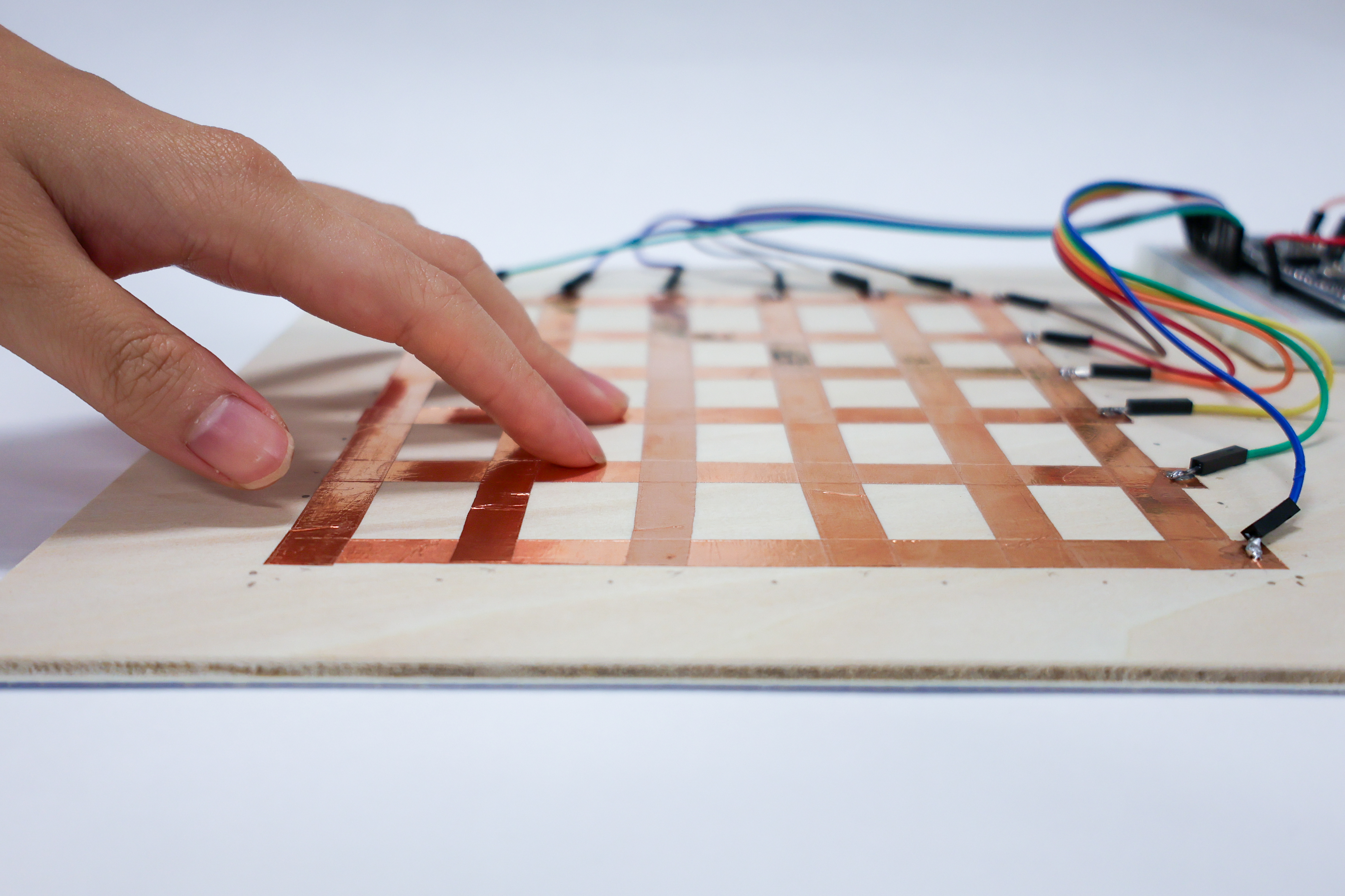 Hands rewiring a dismantled breadboard circuit for photography